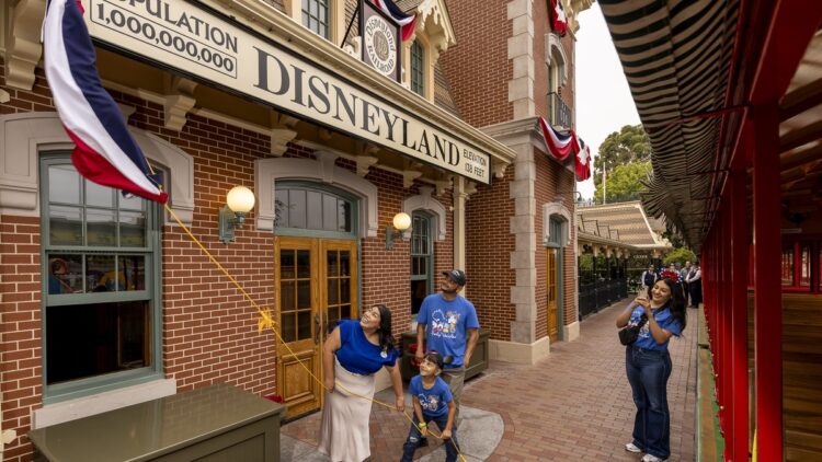 The Robles family unveils the Population 1,000,000,000 sign at Disneyland's train station